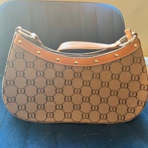 Smaller Tan and Brown Purse. Small wear n tear on strap. Studs on the top.